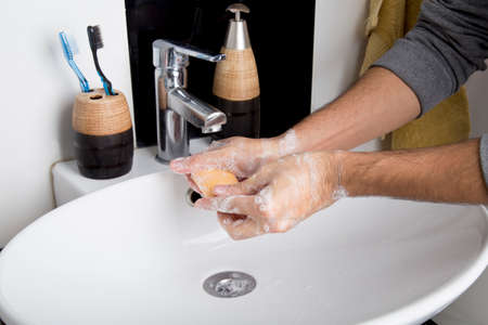 man washing his hands with plenty of foam due to the covid-19 pandemic