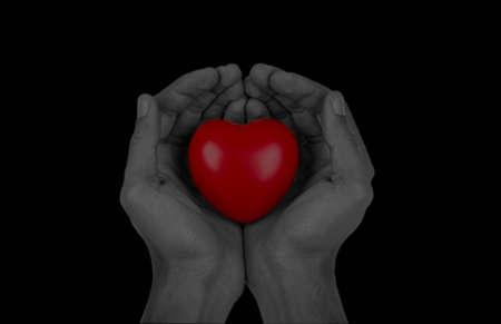 Red heart in hands, isolated on black background. 3d renderingの写真素材