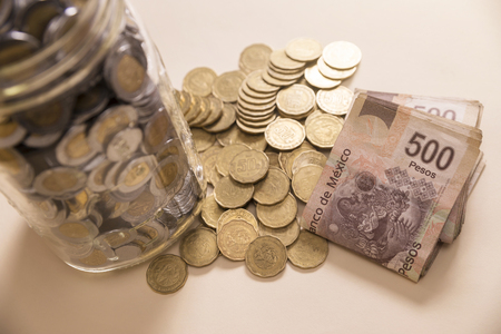 mexican pesos banknotes and coins in glass jarの写真素材