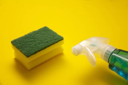 liquid detergent in sparay bottle and sponge on yellow backgroundの写真素材