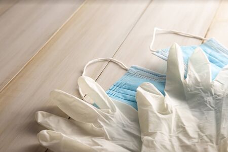 medical latex gloves and face masks for protection on wooden background. Useful for pandemic prevention conceptの写真素材