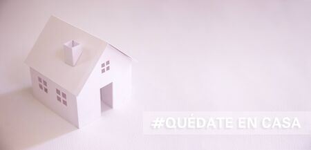 white paper house with text in spanish "quedate en casa" (stay at home)  with copy space. Social distancing campaign during pandemicの写真素材