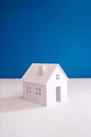 all white paper miniature house with blue color backgroundの写真素材