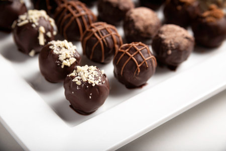 variety of handmade gourmet chocolate truffle candy on a white plateの写真素材