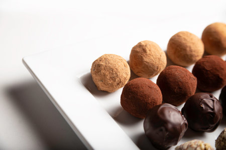 variety of handmade gourmet chocolate truffle candy on a white plateの写真素材