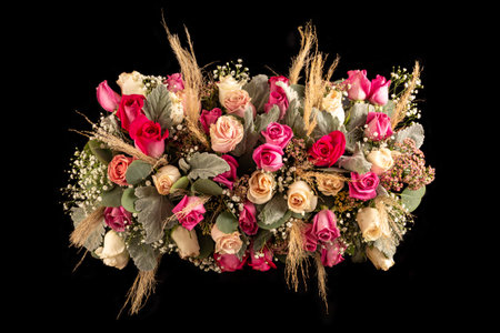 arrangement flower table centerpiece with pink tones roses and foliage. Isolated on black backgroundの写真素材