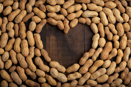 love concept image of heart shape frame made of peanuts on wooden backgroundの写真素材