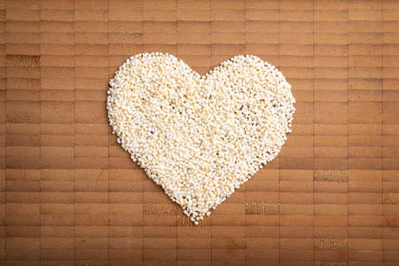 love concept image of heart shape made of amarant grain on bamboo wooden backgroundの写真素材