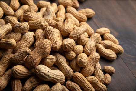 Unpeeled peanuts close up on wooden background. (arachis hypogaea) Edible seeds. Healthy snack nutrition conceptの写真素材