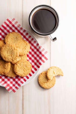 Top view image of Homemade crunchy cookies and a black coffee cup on white wooden rustic table. Flat Layの写真素材