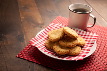 Homemade crunchy cookies and a american coffee cup on broun wooden rustic tableの写真素材