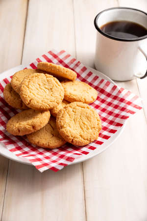 Homemade crunchy cookies and a coffee cup on white wooden rustic tableの写真素材