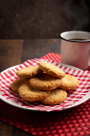 Homemade crunchy cookies and a coffee cup on wooden rustic tableの写真素材