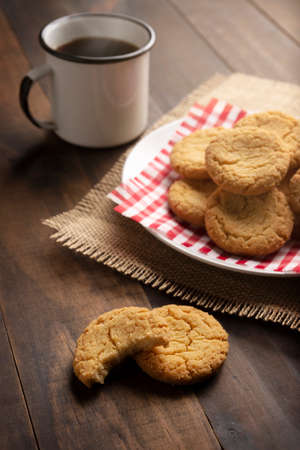 Homemade crunchy cookies and a coffee cup on wooden rustic tableの写真素材