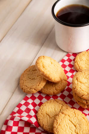 Homemade crunchy cookies and a black coffee cup on white wooden rustic tableの写真素材