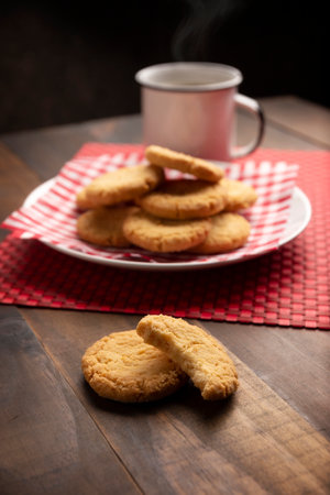 Homemade crunchy cookies and a coffee cup on wooden rustic tableの写真素材