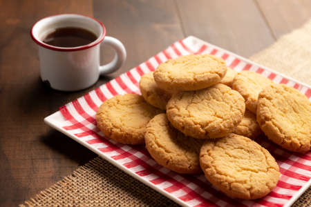 Homemade crunchy cookies and a coffee cup on wooden rustic tableの写真素材