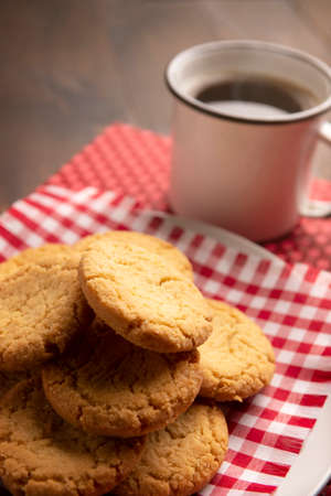 Homemade crunchy cookies and a american coffee cup on wooden rustic tableの写真素材