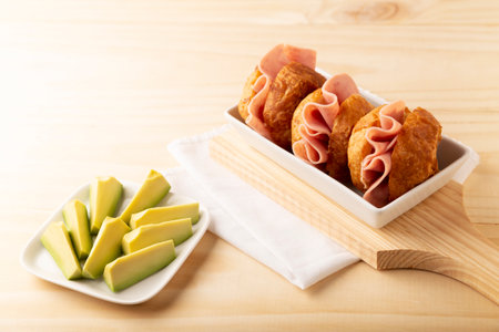 Mini ham sandwich made with "Hojaldra" accompanied by sliced avocado. Hojaldra is a regional bread from CDMX, Mexico that is traditionally filled with mole or hamの写真素材