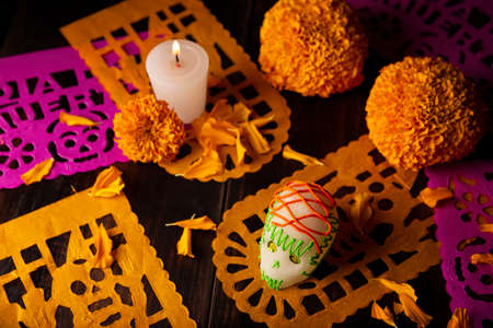 Sugar skull with Candle, Cempasuchil flowers or Marigold and Papel Picado. Decoration traditionally used in altars for the celebration of the day of the dead in Mexicoの写真素材