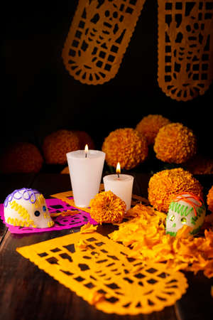 Sugar skulls with Candles, Cempasuchil flowers or Marigold and Papel Picado. Decoration traditionally used in altars for the celebration of the day of the dead in Mexicoの写真素材