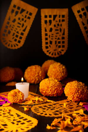 Candle with Cempasuchil orange flowers or Marigold. (Tagetes erecta) and Papel Picado. Decoration traditionally used in altars for the celebration of the day of the dead in Mexicoの写真素材