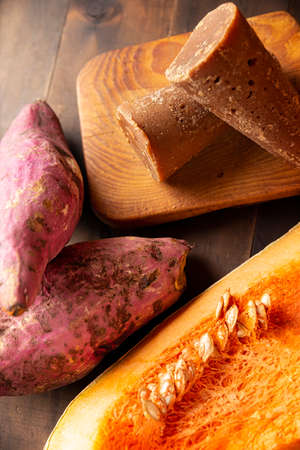 Pumpkin, Sweet potatos Camote and unprocessed sugar cane Piloncillo. Raw Ingredients for mexican traditional dessert for dia de muertos. Close up on rustic wooden tableの写真素材