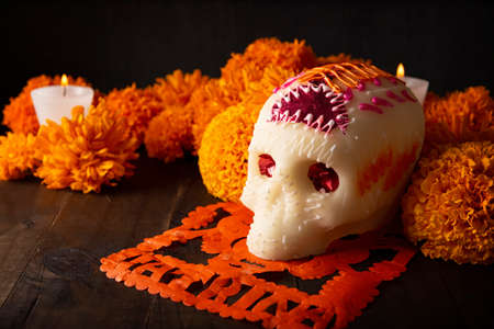 Sugar skull with Candles, Cempasuchil flowers or Marigold and Papel Picado. Decoration traditionally used in altars for the celebration of the day of the dead in Mexicoの写真素材
