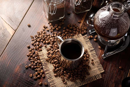 Metallic cup and vacuum coffee maker also known as vac pot, siphon or syphon coffee maker and...