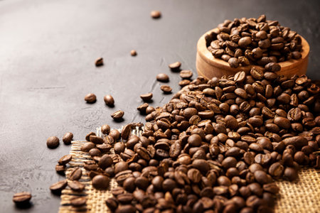 Organic toasted coffee beans on rustic black stone table with copy space for your textの写真素材