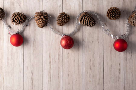 Pine cones and red christmas balls for christmas decoration on rustic white wooden background. Copy space for your textの写真素材
