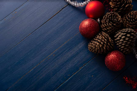Pine cones and red christmas balls for christmas decoration on vintage blue wood background. Copy space for your textの写真素材