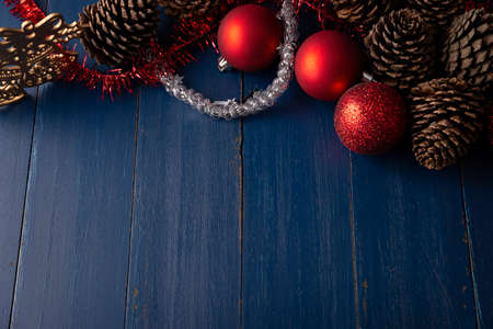 Pine cones and red christmas balls for christmas decoration on vintage blue wood background. Copy space for your textの写真素材