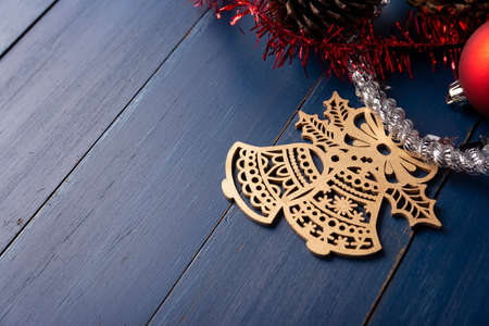 Pine cones and red christmas bells for christmas decoration on vintage blue wood background. Copy space for your textの写真素材