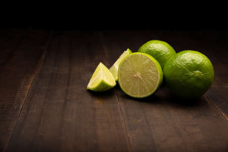 image of lemons close up on rustic wooden surface and black backgroundの写真素材