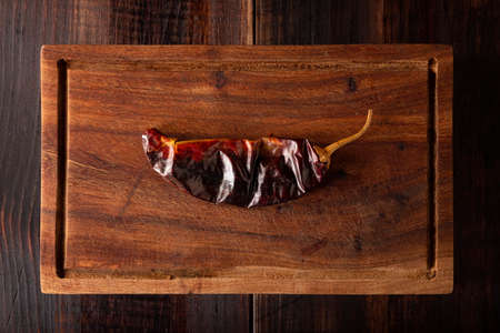 Guajillo chile. This Mexican chili is the dried form of mirasol chili and are used in a variety of Mexican preparations. Rustic wooden board. flat lay imagesの写真素材