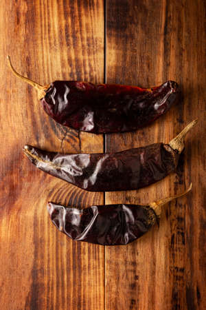 Guajillo chiles. This Mexican chili is the dried form of mirasol chili and are used in a variety of Mexican preparations. Rustic wooden board. flat lay imagesの写真素材