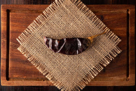 Guajillo chile. This Mexican chili is the dried form of mirasol chili and are used in a variety of Mexican preparations. Rustic wooden board. flat lay imagesの写真素材