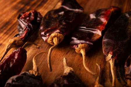 Guajillo chile. This Mexican chili is the dried form of mirasol chili and are used in a variety of Mexican preparations. Rustic wooden board. close-upの写真素材