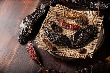 Variety of dried mexican chili. Chile Morita, Guajillo, sChipotle and Pasilla, This Mexican chili is the dried form chilaca chili and are used in a variety of Mexican preparations.の写真素材