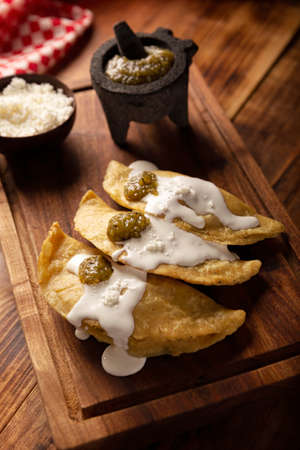 Fried quesadillas. Traditional Mexican appetizer "garnacha". Deep Fried handmade corn tortilla that can be filled with a wide variety of ingredients, cheese, pork rinds, meat, etc.の写真素材