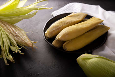 Tamales de Elote, also called Uchepos. Typical Mexican dish. Can be served with green salsa and accompanied by sour cream or served as a dessert covered with caramel or any other sweet toppingの写真素材