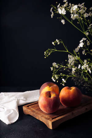 Whole ripe peaches (Prunus persica) on rustic cutting board. copy-spaceの写真素材
