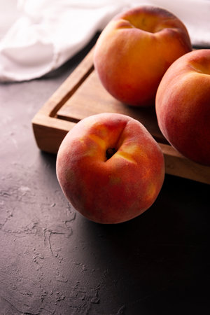 Whole ripe peaches (Prunus persica) on rustic cutting board. Close up pictureの写真素材
