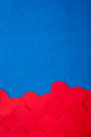 Paper cut red hearts shape on blue textured background with copy space. Concept image. Valentine's day, mother's day, birthday greeting cards, invitation, celebrationの写真素材