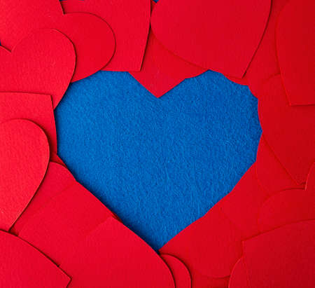 Paper cut red hearts frame on blue textured background with copy space. Concept image. Valentine's day, mother's day, birthday greeting cards, invitation, celebrationの写真素材