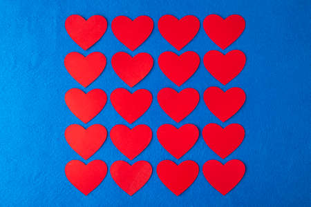 Paper cut red hearts shape on blue textured background with copy space. Concept image. Valentine's day, mother's day, birthday greeting cards, invitation, celebrationの写真素材