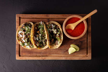 Tacos from Suadero. Fried meat in a corn tortilla. Street food from CDMX, Mexico, traditionally accompanied with cilantro, onion and spicy red sauceの写真素材