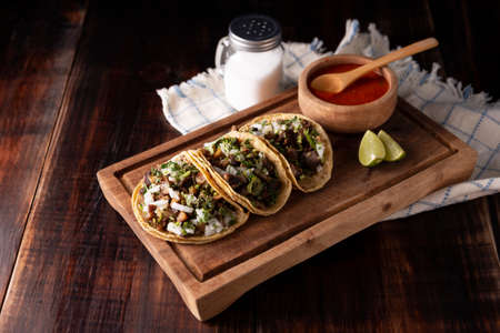 Tacos from Suadero. Fried meat in a corn tortilla. Street food from CDMX, Mexico, traditionally accompanied with cilantro, onion and spicy red sauceの写真素材
