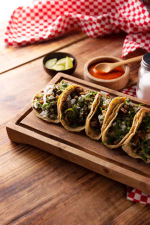 Tacos from Suadero. Fried meat in a corn tortilla. Street food from CDMX, Mexico, traditionally accompanied with cilantro, onion and spicy red sauceの写真素材